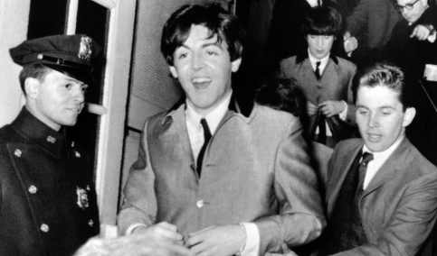 Paul maintains a cheerful expression as he rushes away from the screaming crowds after a 1964 performance at Carnegie Hall. (AP, via In Focus)