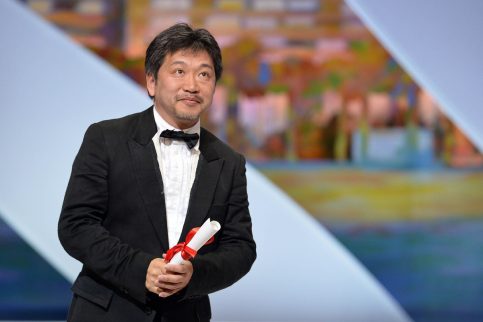 Japanese director Hirokazu Kore-Eda poses on stage on May 26, 2013 after being awarded with the Prix du Jury (Jury's Prize) for the film "Like Father, Like Son" during the closing ceremony of the 66th Cannes film festival in Cannes. AFP PHOTO / ALBERTO PIZZOLI
